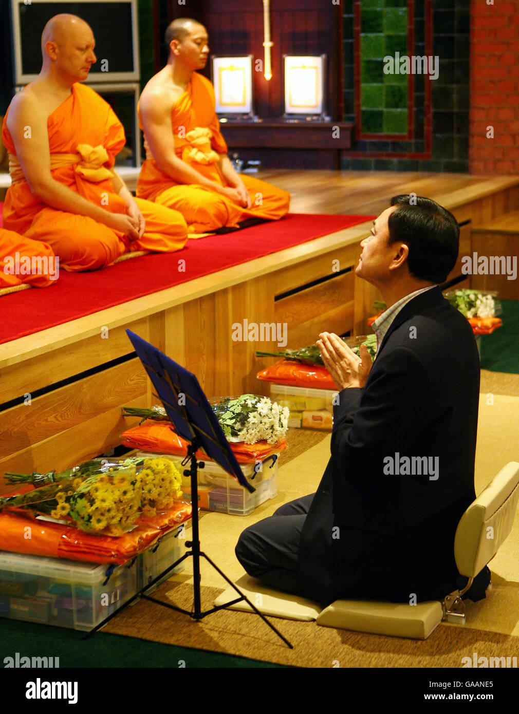 Dr. Thaksin Shinawatra, former Prime Minister of Thailand, prays with monks at the Dhammakaya Centre for Buddist Meditation in Knaphill, Surrey, a year after being ousted from office. Stock Photo