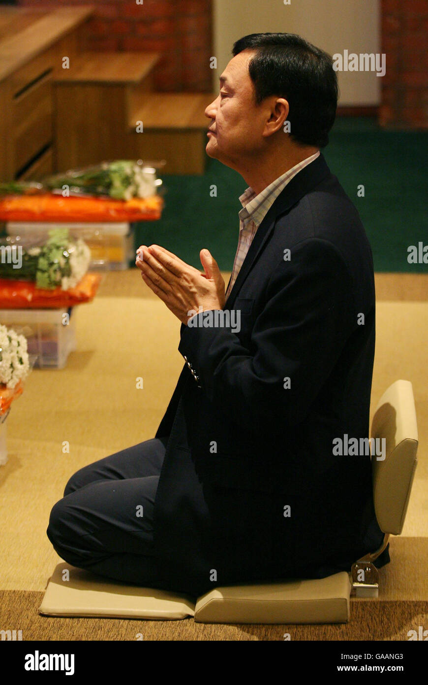 Dr. Thaksin Shinawatra, former Prime Minister of Thailand, during prayers at the Dhammakaya Centre for Buddist Meditation in Knaphill, Surrey, a year after being ousted from office. Stock Photo
