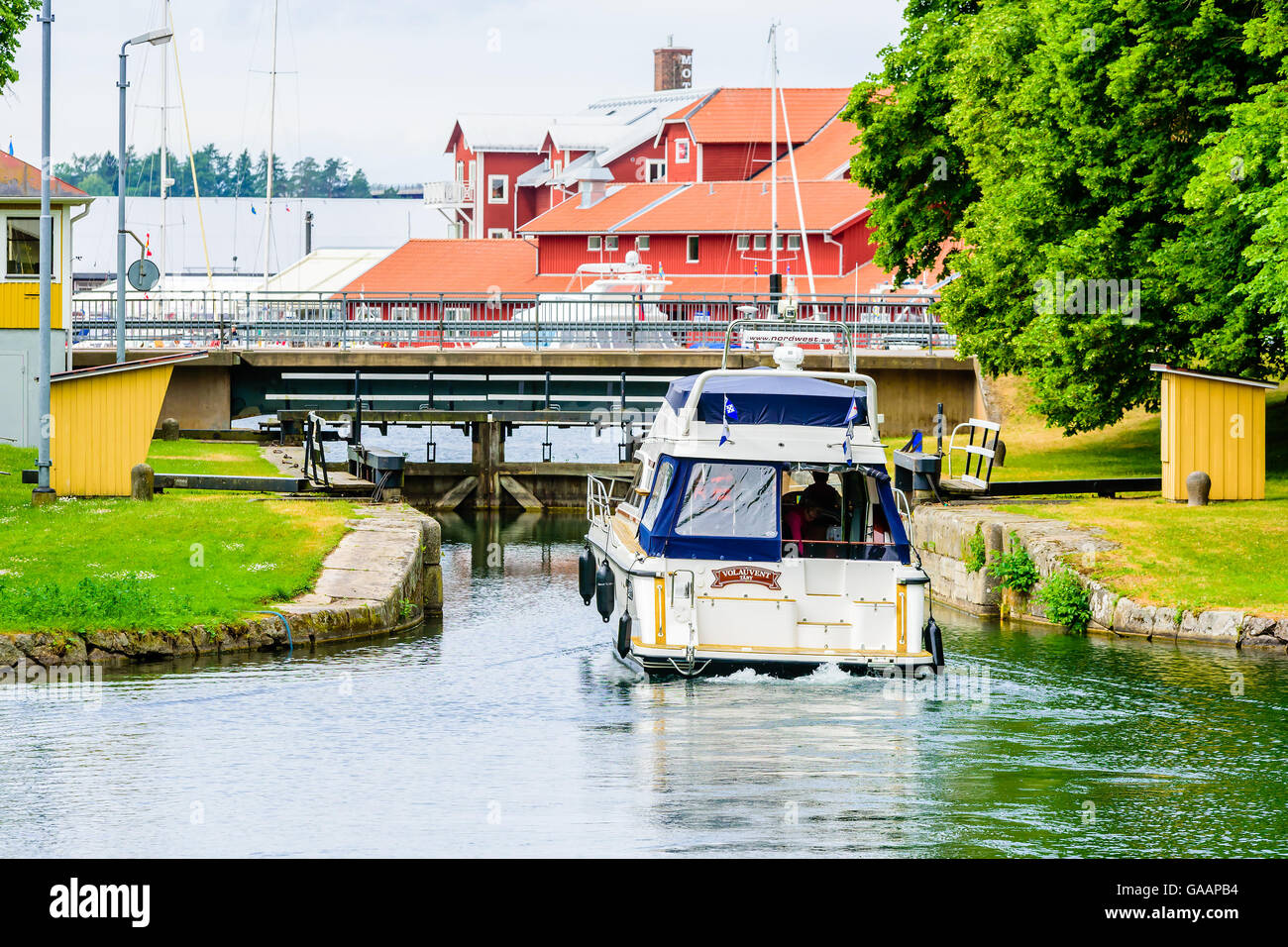 Motala, Sweden - June 21, 2016: Nord West 390 boat approaching canal lock at slow speed. Motala marina visible behind lock. Stock Photo