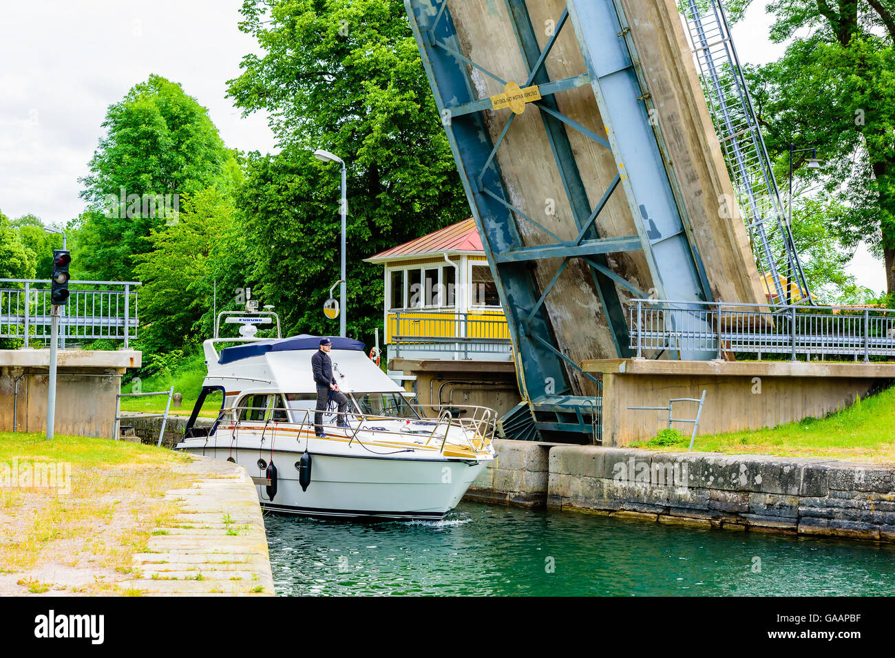 Motala, Sweden - June 21, 2016: Nord West 390 motorboat passing under a movable bridge with crewmember standing on deck with rop Stock Photo