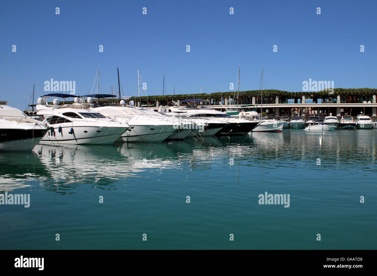 View in original section of  Port Adriano marina with Philippe Starck designed superyacht marina and commercial centre Stock Photo