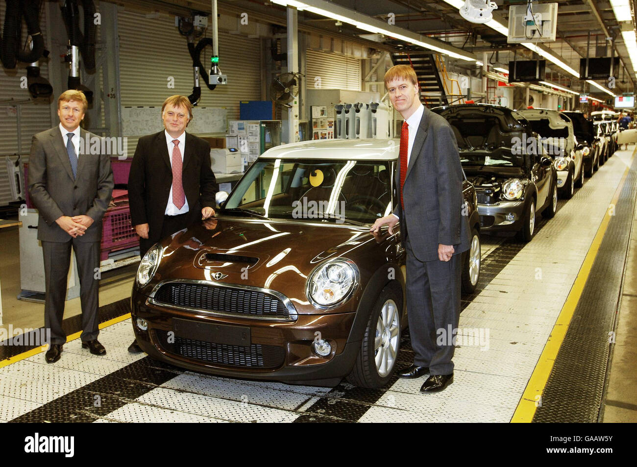Oliver Zipse Managing Director of BMW Group Plant Oxford, Andrew Smith MP  Oxford East and Competitiveness Minister Stephen Timms (left to right) at  the end of the production line of the new