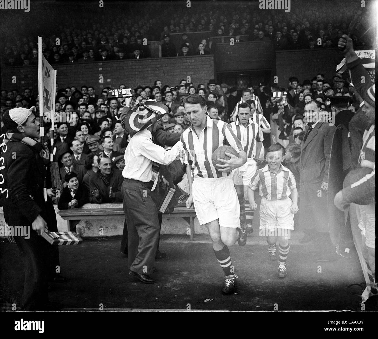 West Bromwich Albion's Ray Barlow (c) leads his team out, cheered on by Pancho Johnny (l) Stock Photo