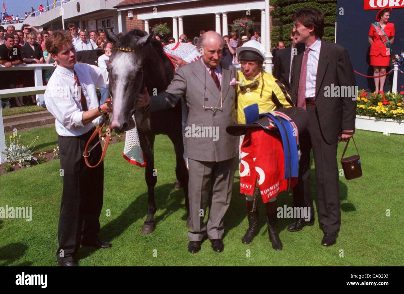 Environment Friend in the winner's enclosure with his jockey George Duffield (second r) and trainer James Fanshawe (r) after winning the Coral Eclipse Stakes Stock Photo