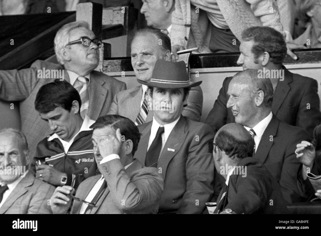 Rock and Roll legend Elton John (centre with hat) sits next to Watford Manager Graham Taylor (l) and General Manager Bertie Mee (r) Stock Photo