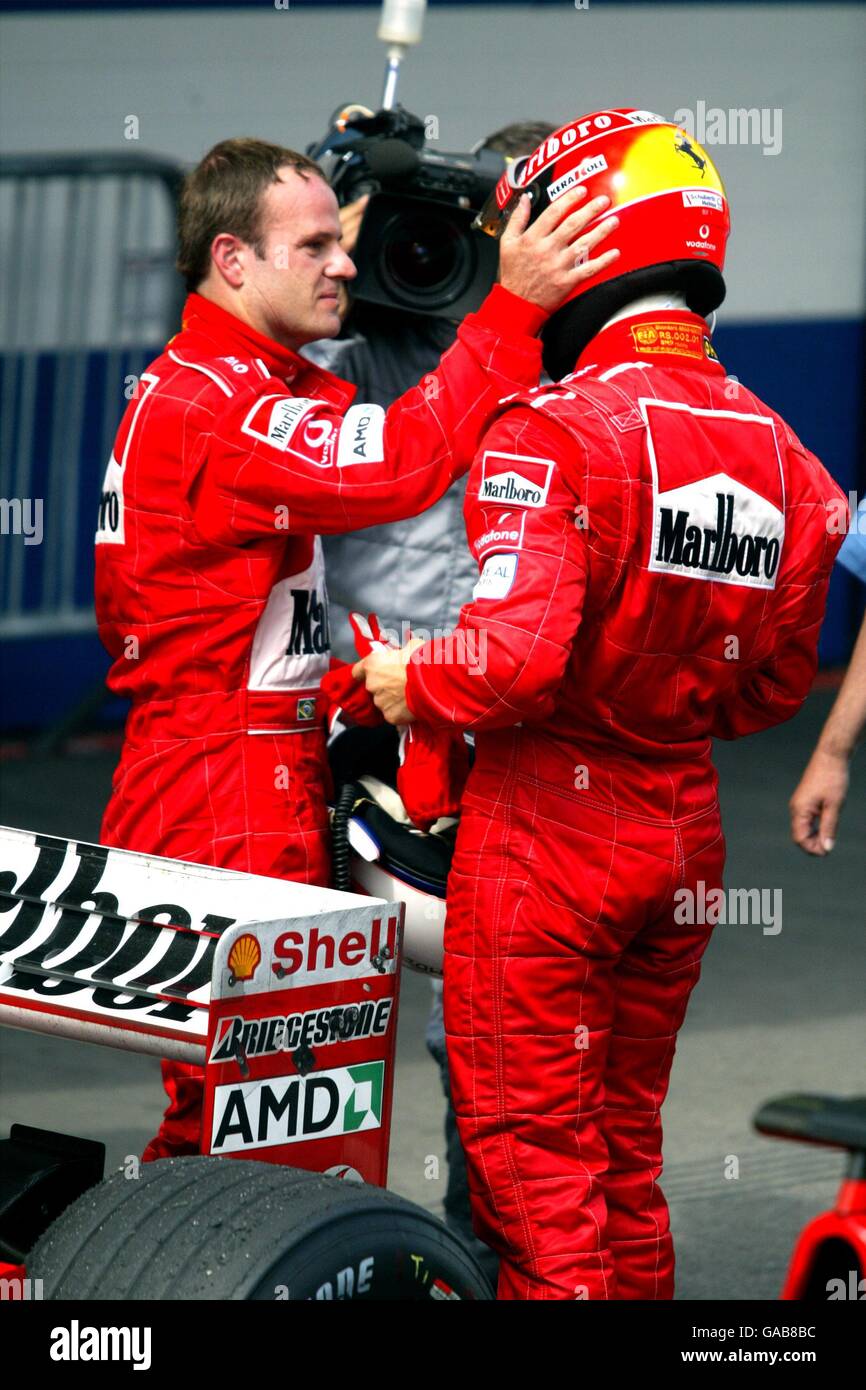Ferrari's Rubens Barrichello (l) gives teamate Michael Schumacher (r) a reassuring pat on his helmet Stock Photo