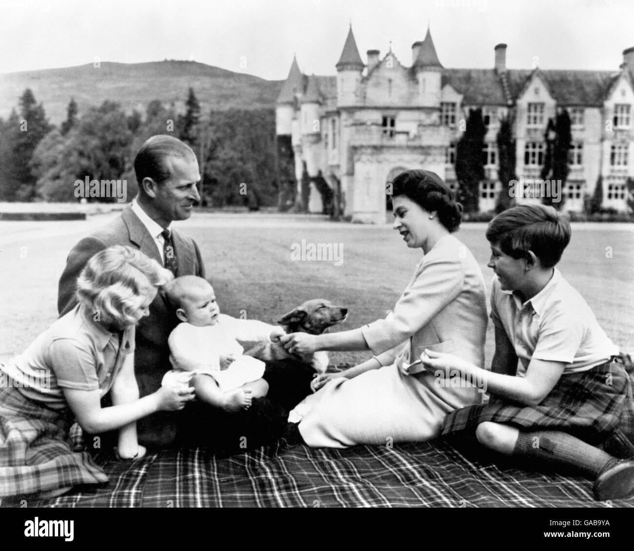 Seated comfortably on a tartan rug, members of the Royal family play with Prince Andrew in the grounds of Balmoral. Stock Photo