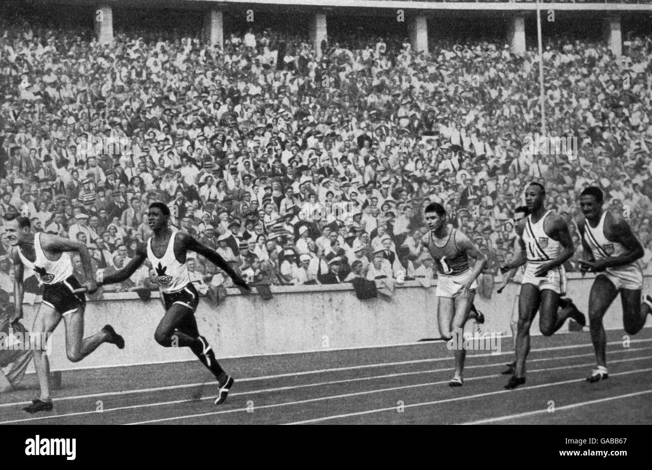 USA's Jesse Owens (second r) slows down after handing the baton to teammate Ralph Metcalfe (r) for the final leg. The US team set a new world record of 39.8 secs Stock Photo