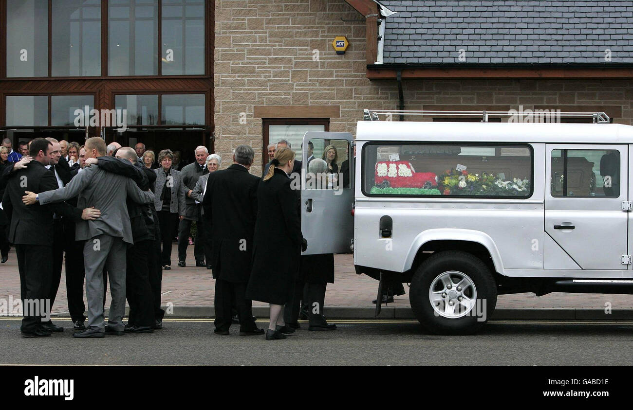 Pall bearers, including Alister Mcrae, pictured in a grey suit, have a group cuddle after carrying the coffin of Graeme Duncan 37, who died in the helicopter crash that killed rally driver Colin McRae. Stock Photo