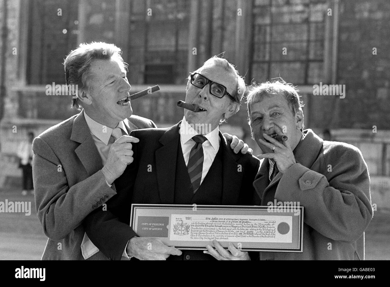 Comedy actor Eric Sykes (centre), taking a break from rehearsals for Peter Pan in which he co-stars with Lulu at the Manchester Opera House, is congratulated by his cigar-puffing friends, singer Max Bygraves (left) and scriptwriter Johnny Speight, after his admittance to the Freedom of the City of London at Guildhall, London today. Stock Photo