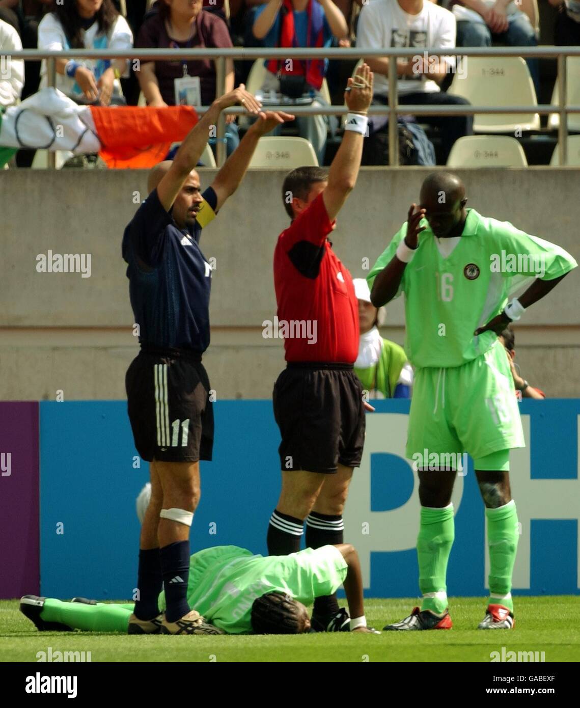 Soccer - FIFA World Cup 2002 - Group F - Argentina v Nigeria. Referee Giles Veissiere of France and Argentinan captain Juan Veron call for the physio as Nigeria Nwankwo Kanu lies injured on the pitch Stock Photo