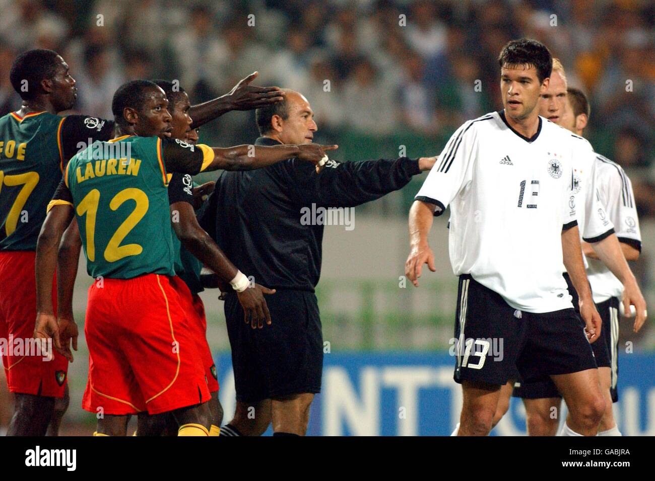 L-R: Cameroon players Marc-Vivien Foe, Lauren and Samuel Eto'o point out the culprit to referee Antonio Lopez Nieto as Germany's Michael Ballack looks on Stock Photo