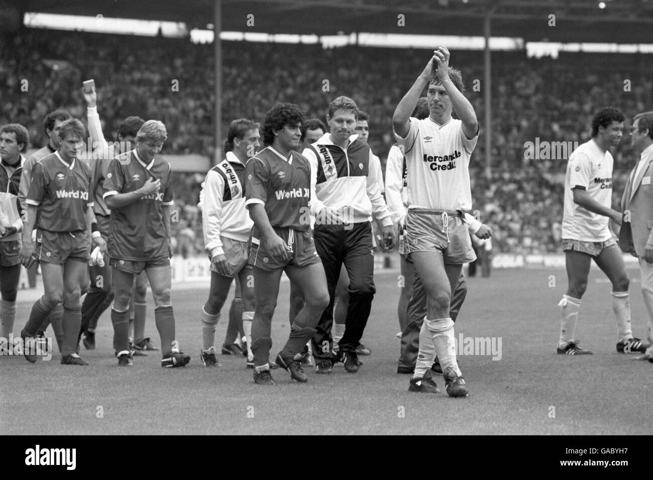 Bryan Robson (clapping) leads out the Football League XI along side