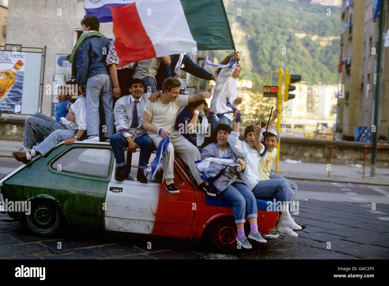 Napoli fans celebrate winning the league title by sitting on a car