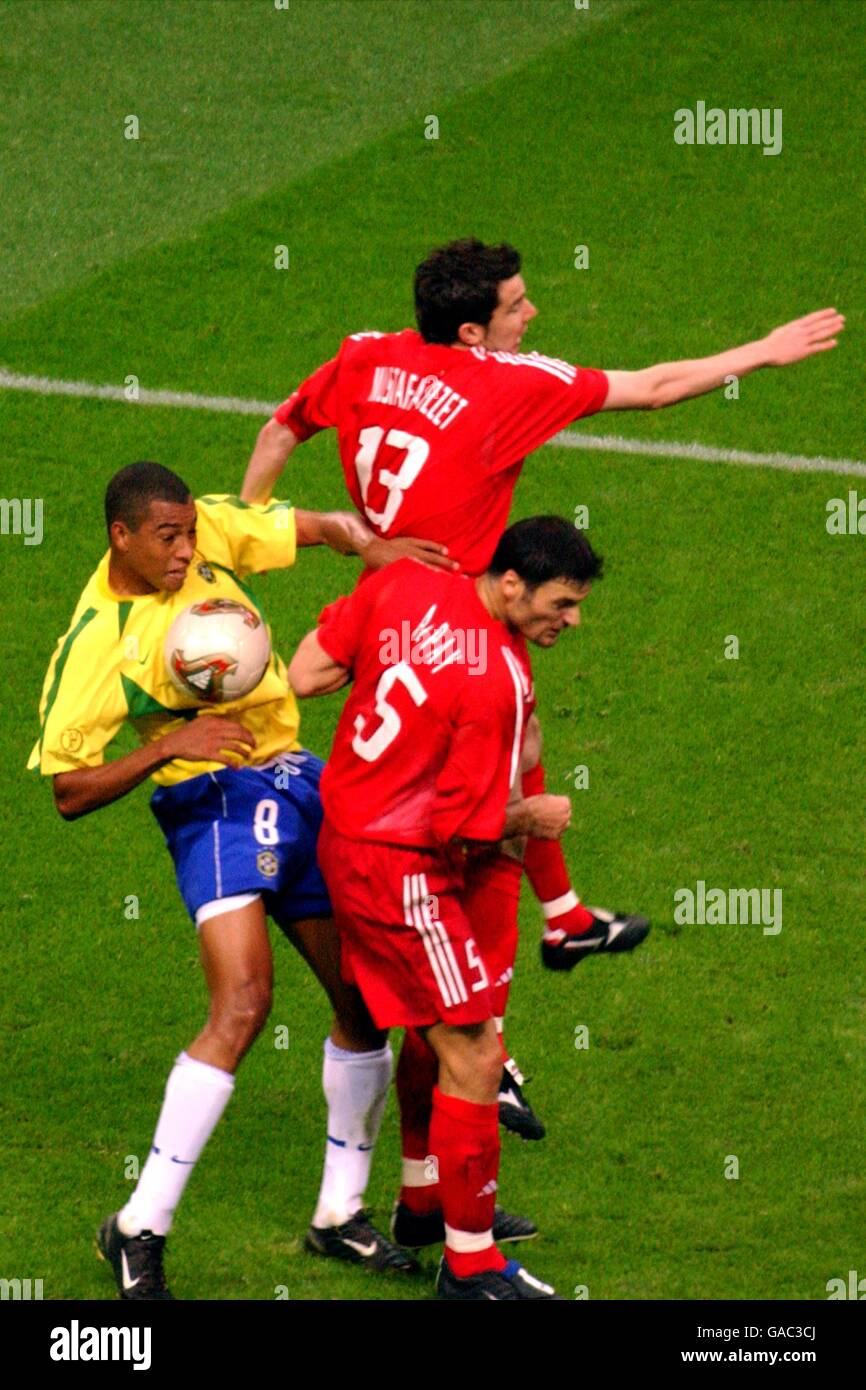 Soccer - FIFA World Cup 2002 - Semi Final - Brazil v Turkey. Brazil's Gilberto Silva (l) battles for the ball with Turkey's Muzzy Izzet (top) and Alpay Ozalan Stock Photo