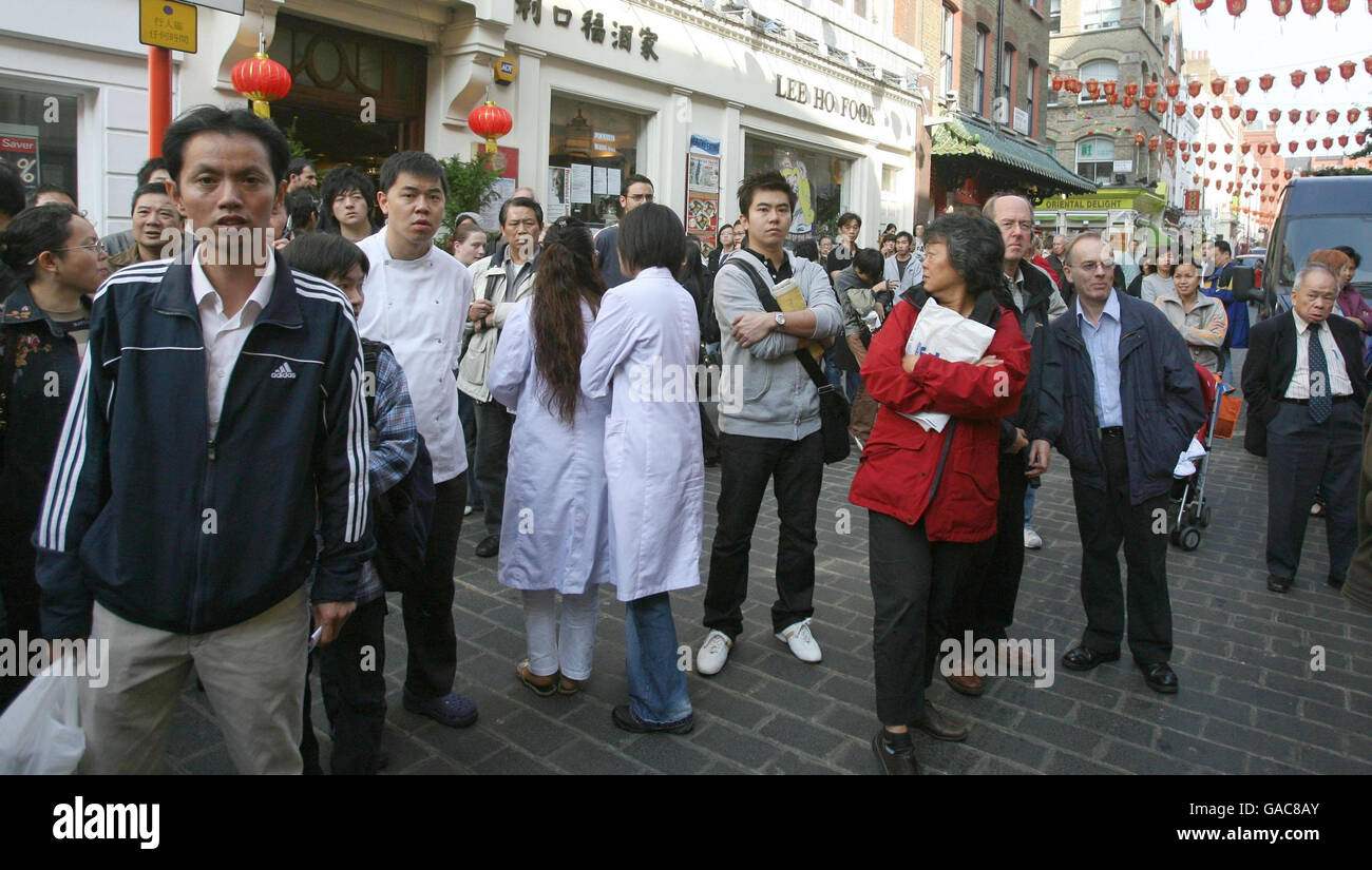 Members of the public stop and watch as immigration officials and ...