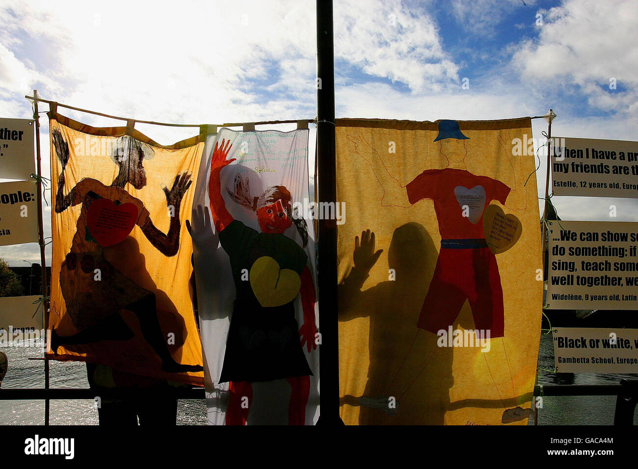 Children stand behind art at an event near the Irish Famine Memorial on the Quays in the City Centre, Dublin to mark United Nations Day for the Eradication of World Poverty. Stock Photo