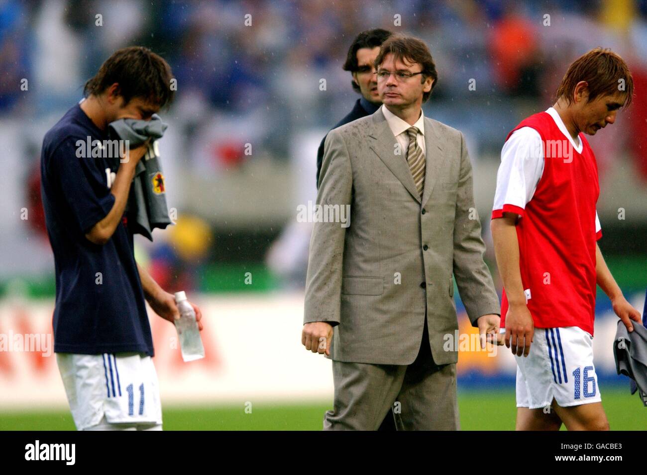 Takayuki Suzuki (11) and Koji Nakata leave the field with manager Philippe Troussier after being knocked out of the FIFA 2002 World Cup after losing to Turkey 1-0 Stock Photo