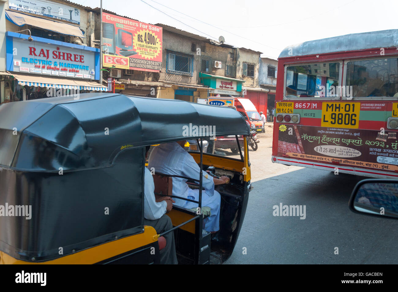 Street scene in Mumbai Maharashtra India public transport bus and tuk tuk. Stock Photo