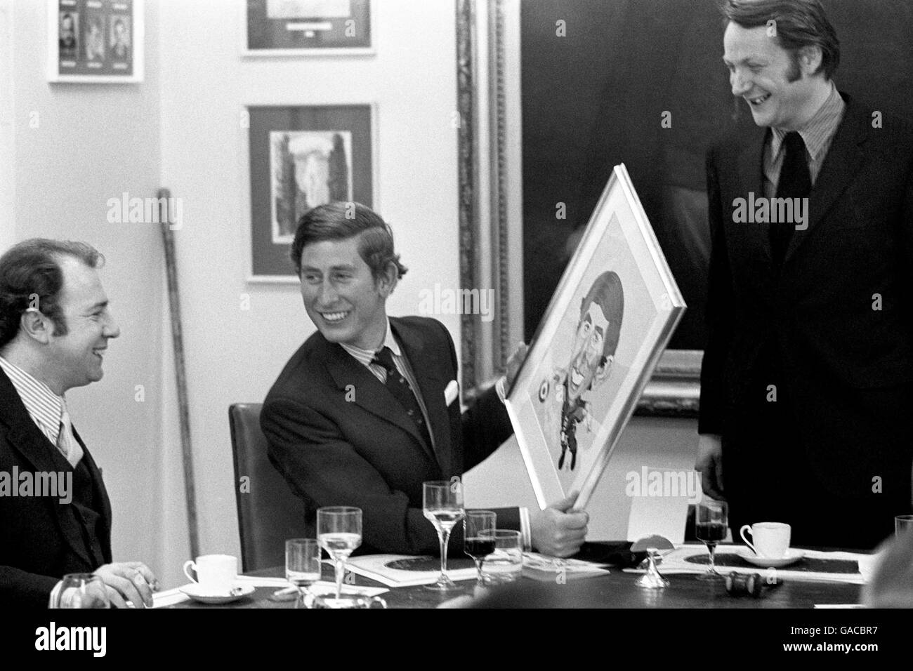 Not for the first time, the magazine raises a royal smile - this time it's from Prince Charles, who is featured on the front cover of next week's issue. The caricature was presented tohim during his visit to the magazine in Tudor Street, today. On the left is Mr Alan Coren, Deputy Editor of Punch. Stock Photo
