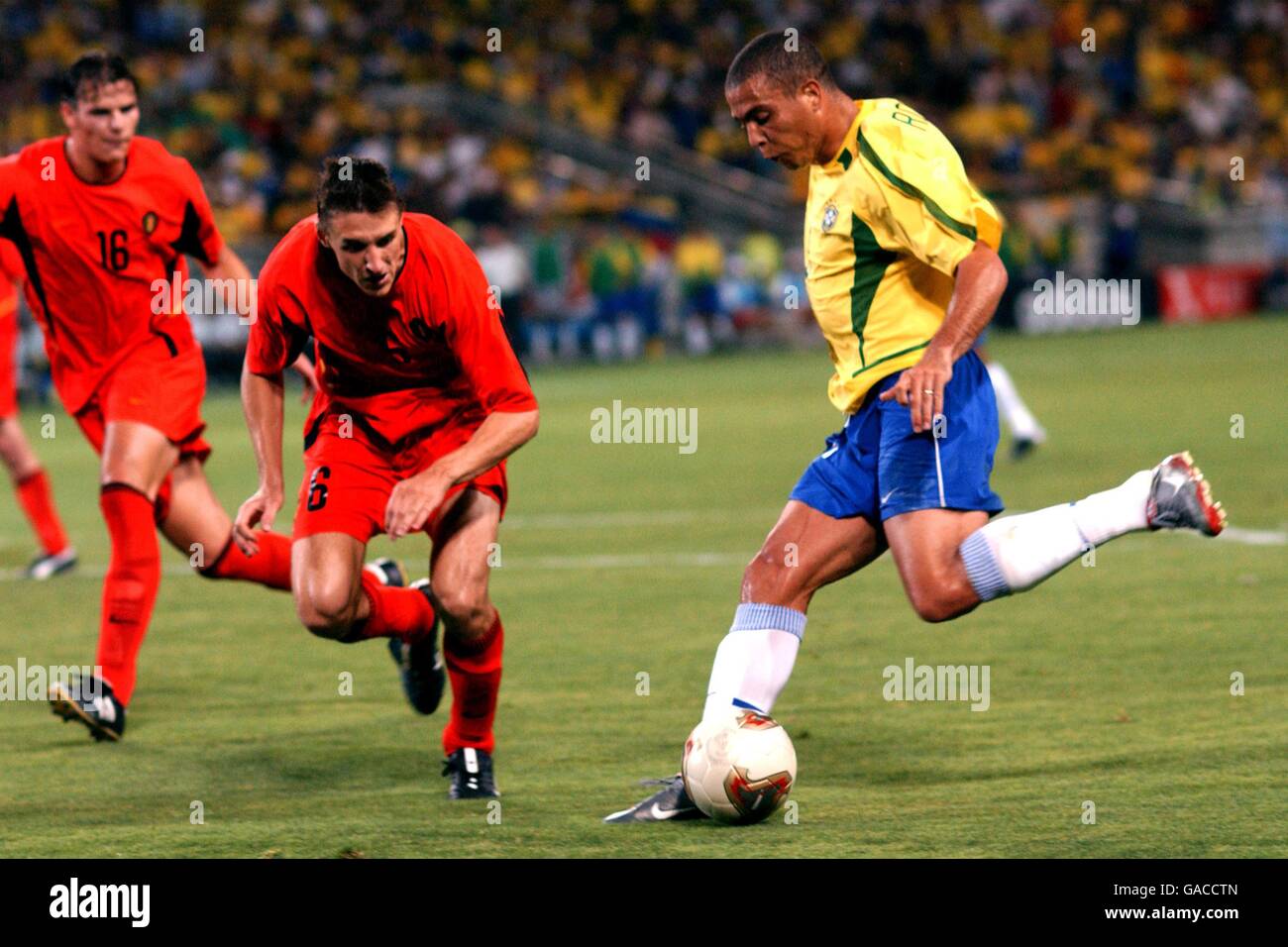 Soccer - FIFA World Cup 2002 - Second Round - Brazil v Belgium. Brazil's Ronaldo (r) gets in a shot on goal despite the attentions of Belgium's Daniel Van Buyten (l) and Timmy Simons Stock Photo