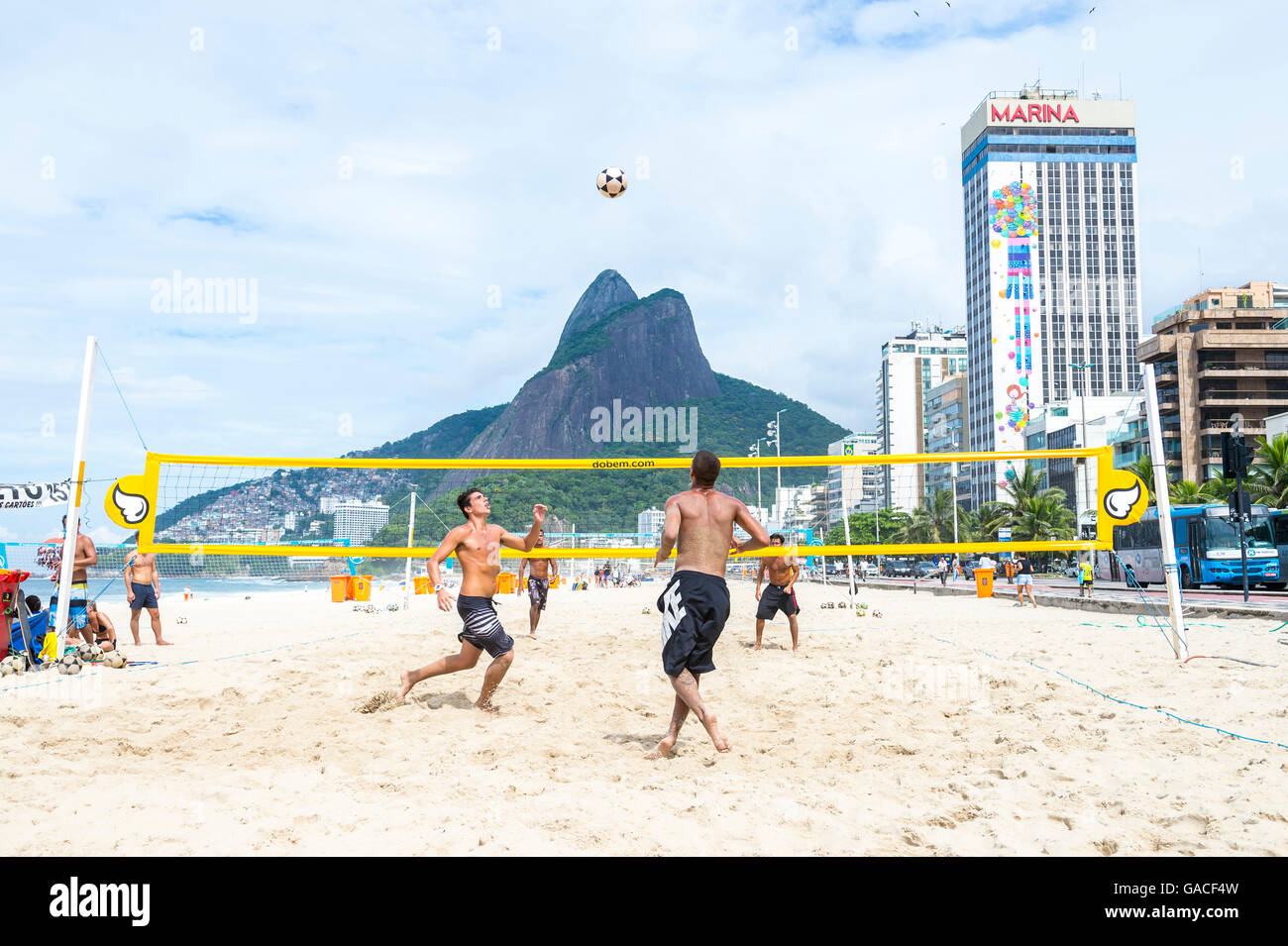 RIO DE JANEIRO - MARCH 17, 2016: Young Brazilian men play a game of futevolei (footvolley), combining football and volleyball. Stock Photo