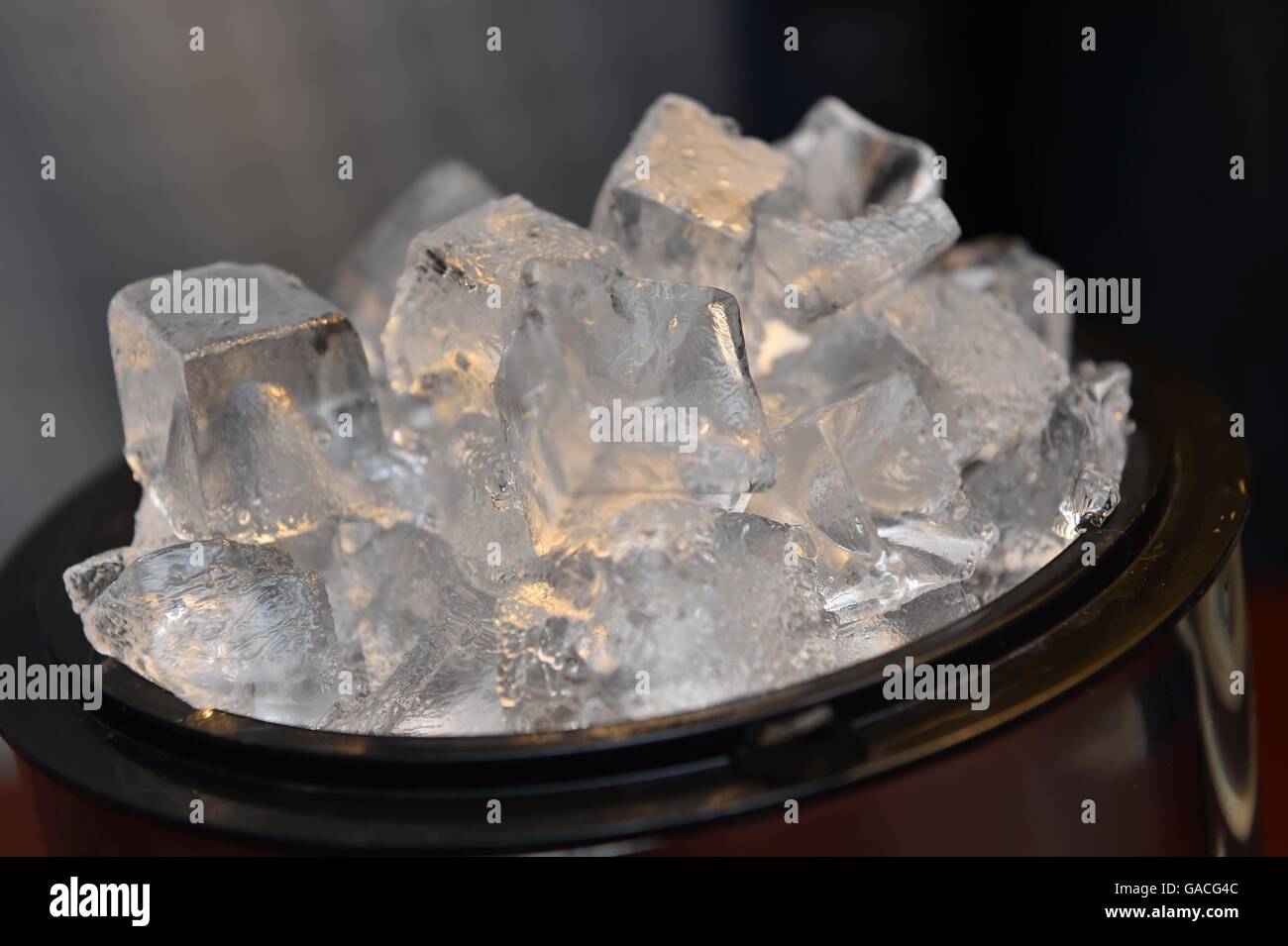 Ice cubes in a cooler bucket and tongs next to it Stock Photo
