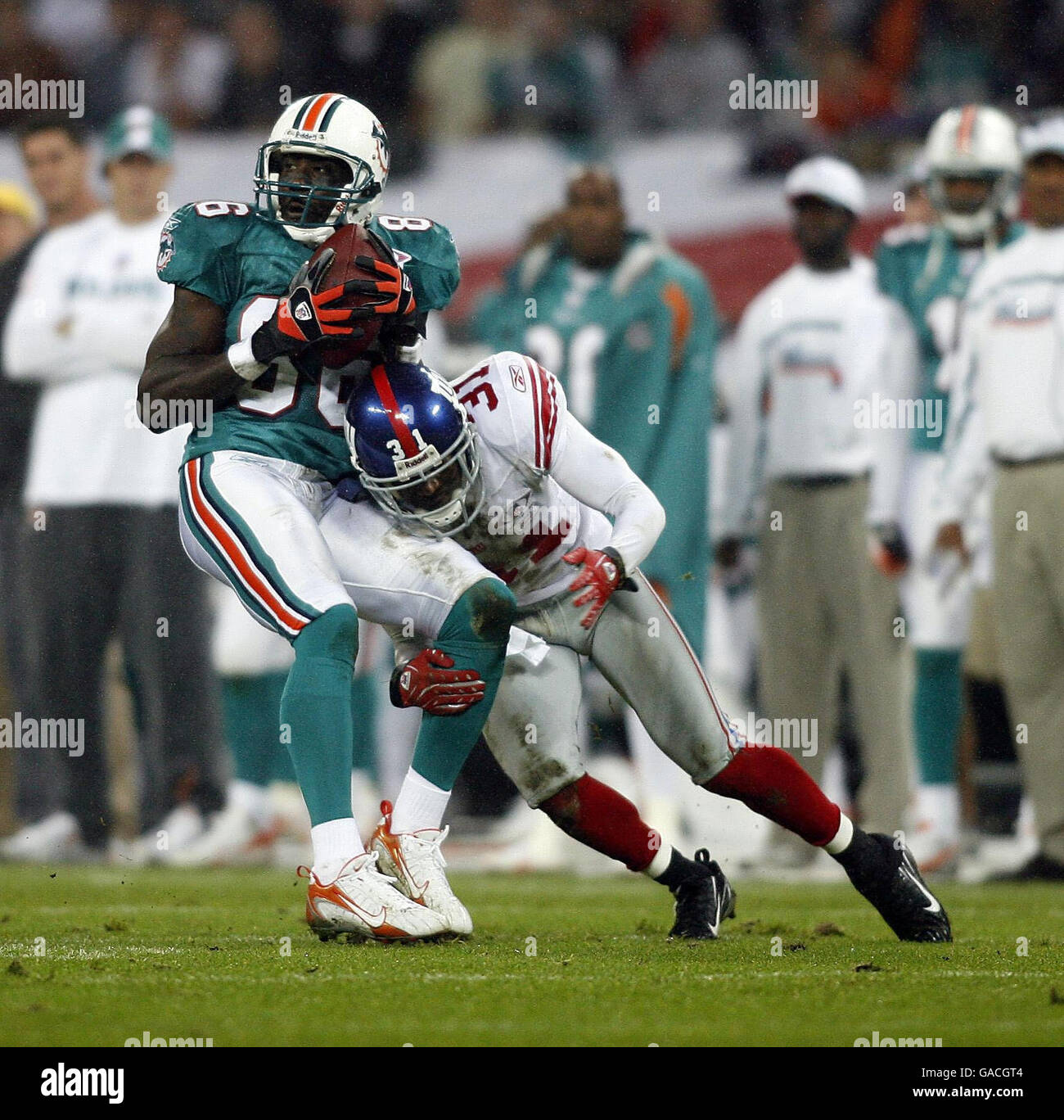 Miami Dolphins player Marty Booker is tackled by New York Giants player Aaron Ross during the NFC Eastern Division match at Wembley, London. Stock Photo