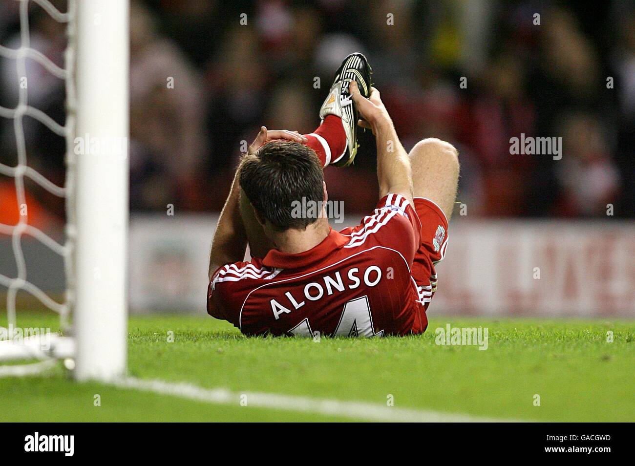 Liverpool 's Xabi Alonso lays injured on the ground clutching his foot  Stock Photo - Alamy