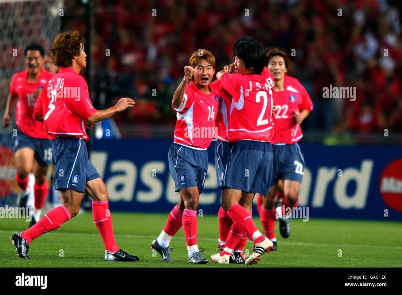 Republic Of Korea's Eul Yong Lee (hidden) is mobbed by his teammates after scoring a spectacular free-kick equaliser Stock Photo