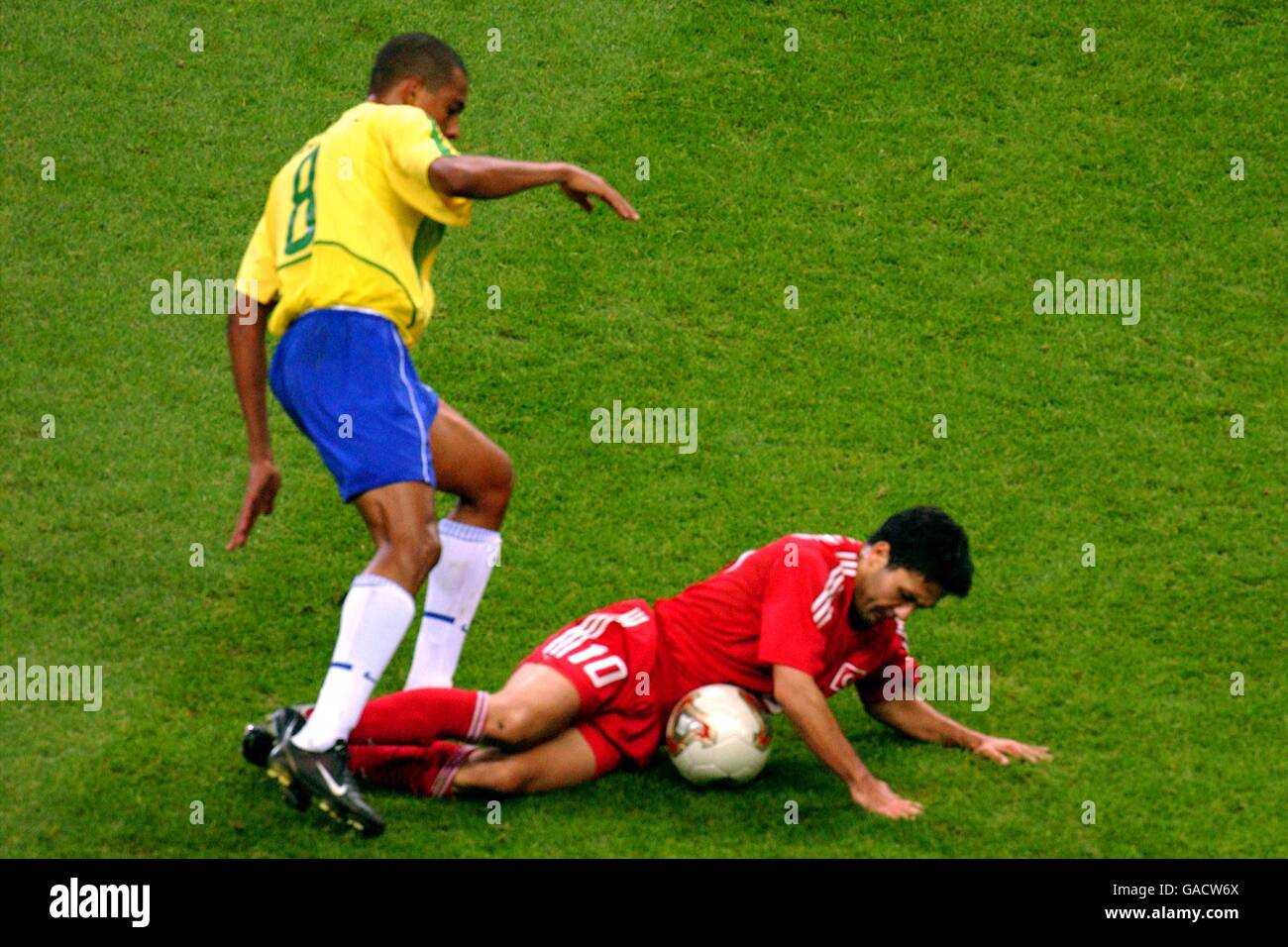 Turkey's Yildiray Basturk (r) takes a tumble after a challenge by Brazil's Gilberto Silva Stock Photo