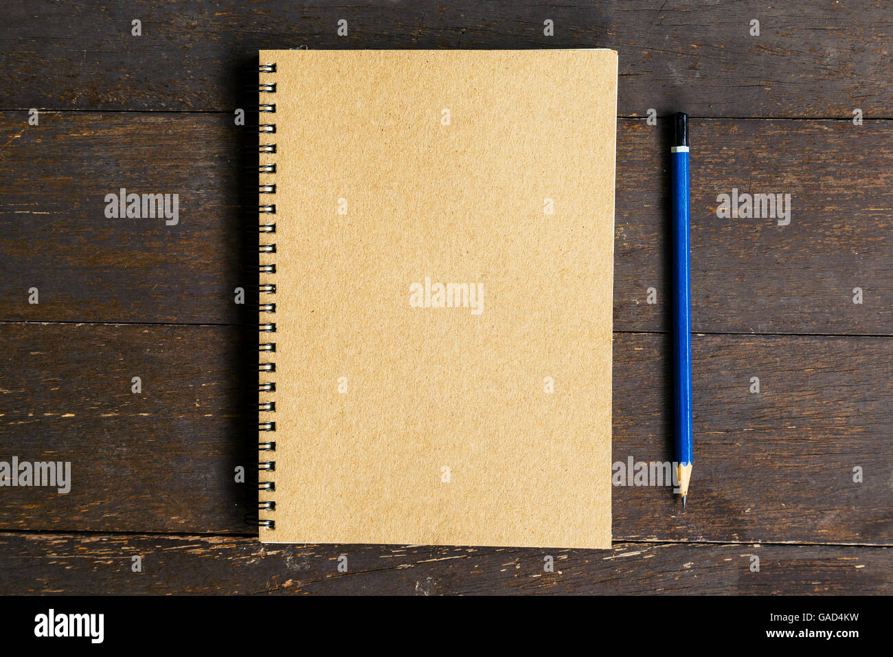 brown book and pencil on wood table background with space Stock Photo