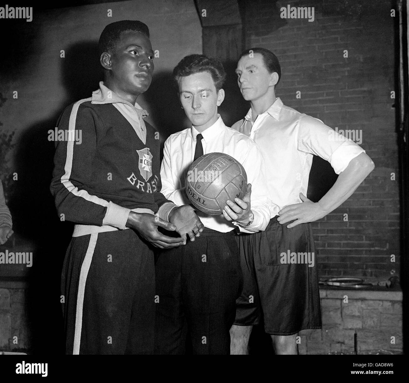 Wax moulder George Hopkins Jr (c) places a football into the hands of Madame Tussaud's latest addition, Brazil's Pele, as a wax Sir Stanley Matthews (r) stares off into the distance Stock Photo