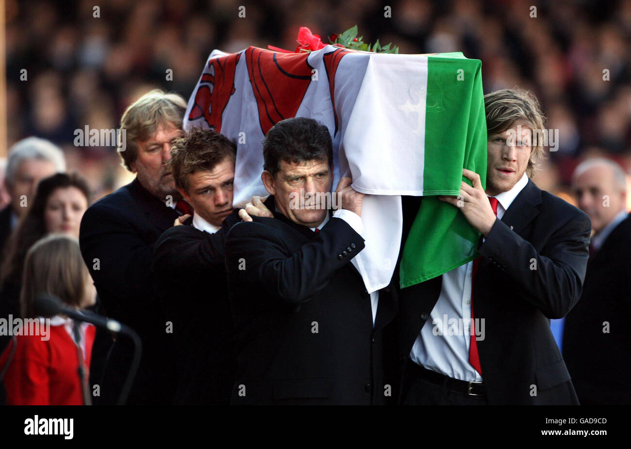 The coffin of Wales and Llanelli rugby legend Ray Gravell is carried in to Stradey Park, the home of Llanelli Rugby Club today by current and former player, left to right Derrick Quinnell, Dwayne Peel, Gareth Jenkins and Simon Easterby, also bearing the coffin were Stephen Jones and Delme Thomas (not seen). A public service was held in the stadium followed by a private cremation. Stock Photo