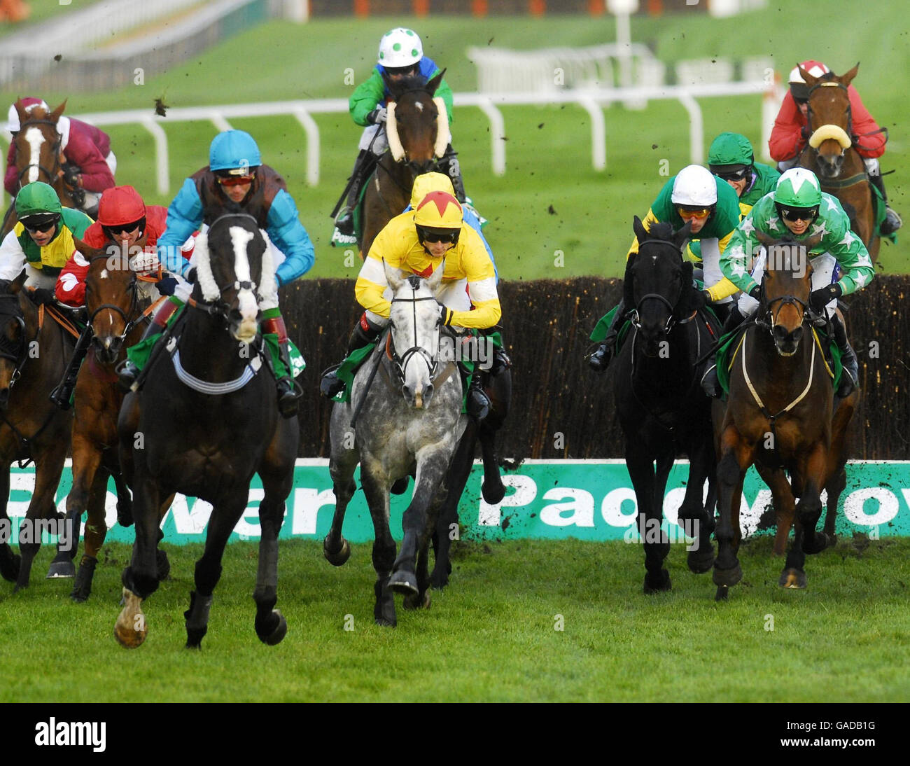 Granit Jack ridden by Liam Heard (centre) comes away from the fence in front of the grandstand at Cheltenham Racecourse. Stock Photo