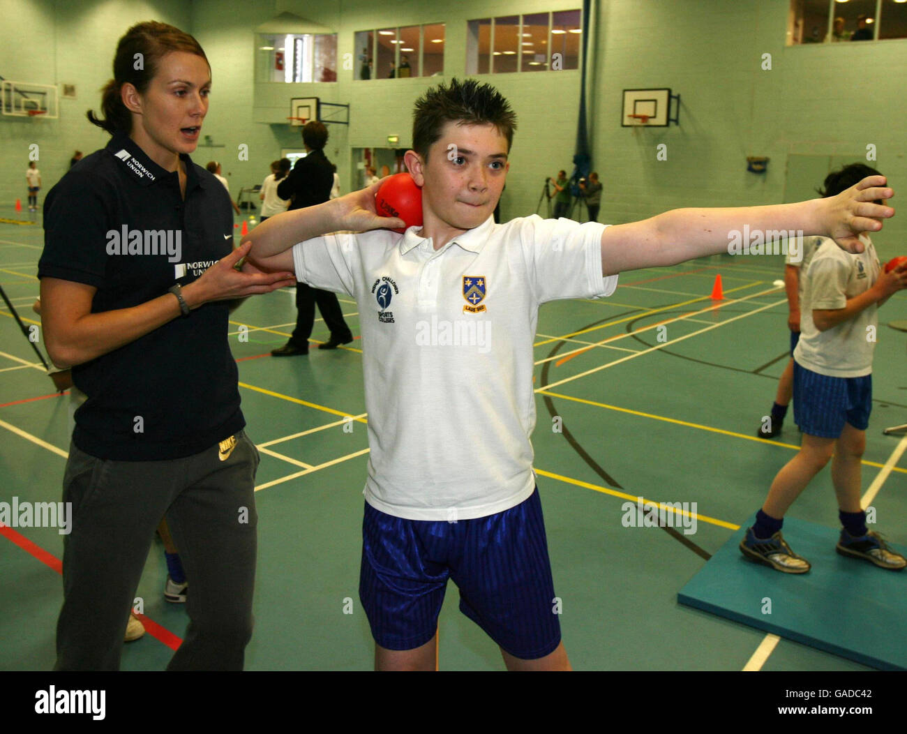 Great Britain's Kelly Sotherton the World Bronze medal-winning heptathlete coaches children in the shot putt during a photocall at the Bishop Chaloner Catholic School, Sports College, Birmingham. Stock Photo