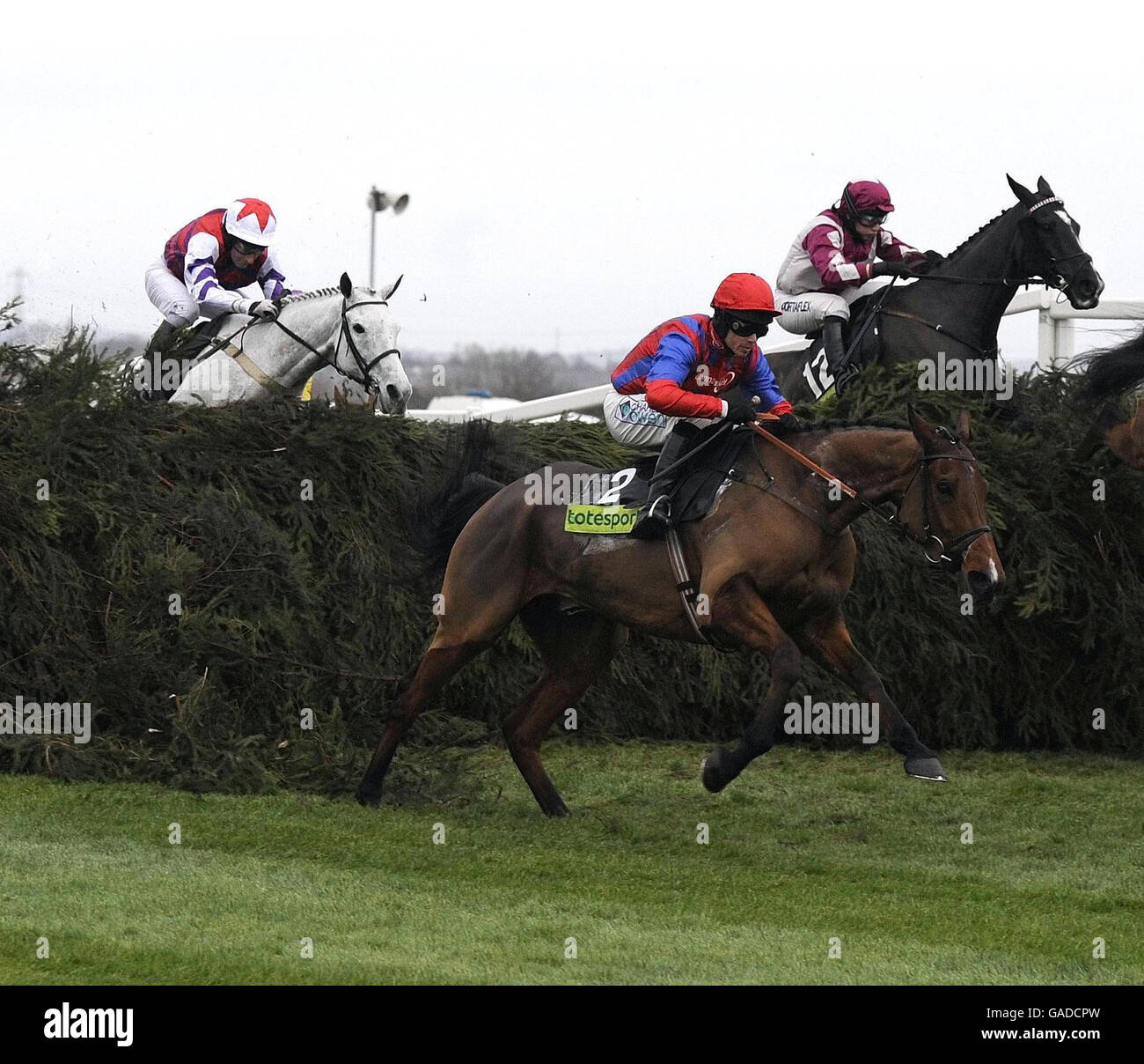 Jockey Sam Thomas and Mr Pointment (red cap) jump the Chair fence before going on to win in the totesport.com Becher Chase Handicap at Aintree Racecourse. Stock Photo