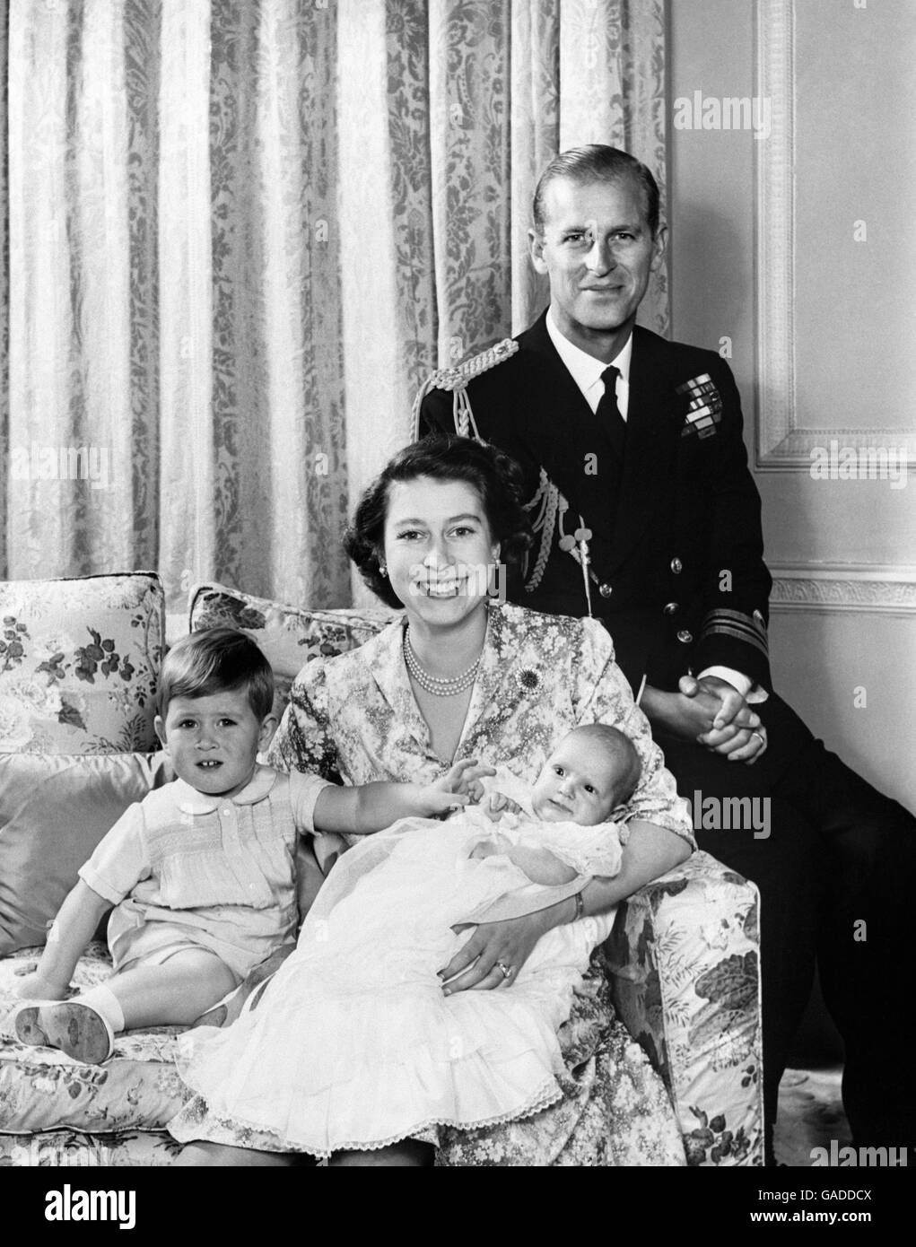 Princess Elizabeth and the Duke of Edinburg with their children Prince Charles and Princess Anne, taken in the private sitting room of Clarence House, their London home. The Duke was wearing the uniform of a Lieutenant-Commander of the Royal Navy. Stock Photo