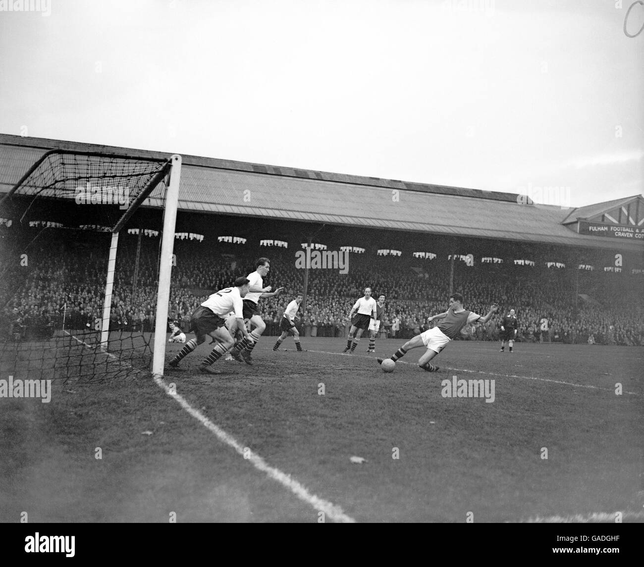 Burnley's Jimmy Robson (r) drags his shot wide as Fulham's George Cohen (no2) and Derek Lampe (third l) run out to try to block the shot Stock Photo