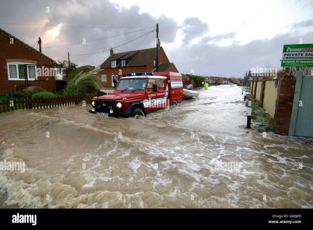 A Fire Rescue vehicle makes its way through a flooded street at Walcott near Great Yarmouth. Stock Photo
