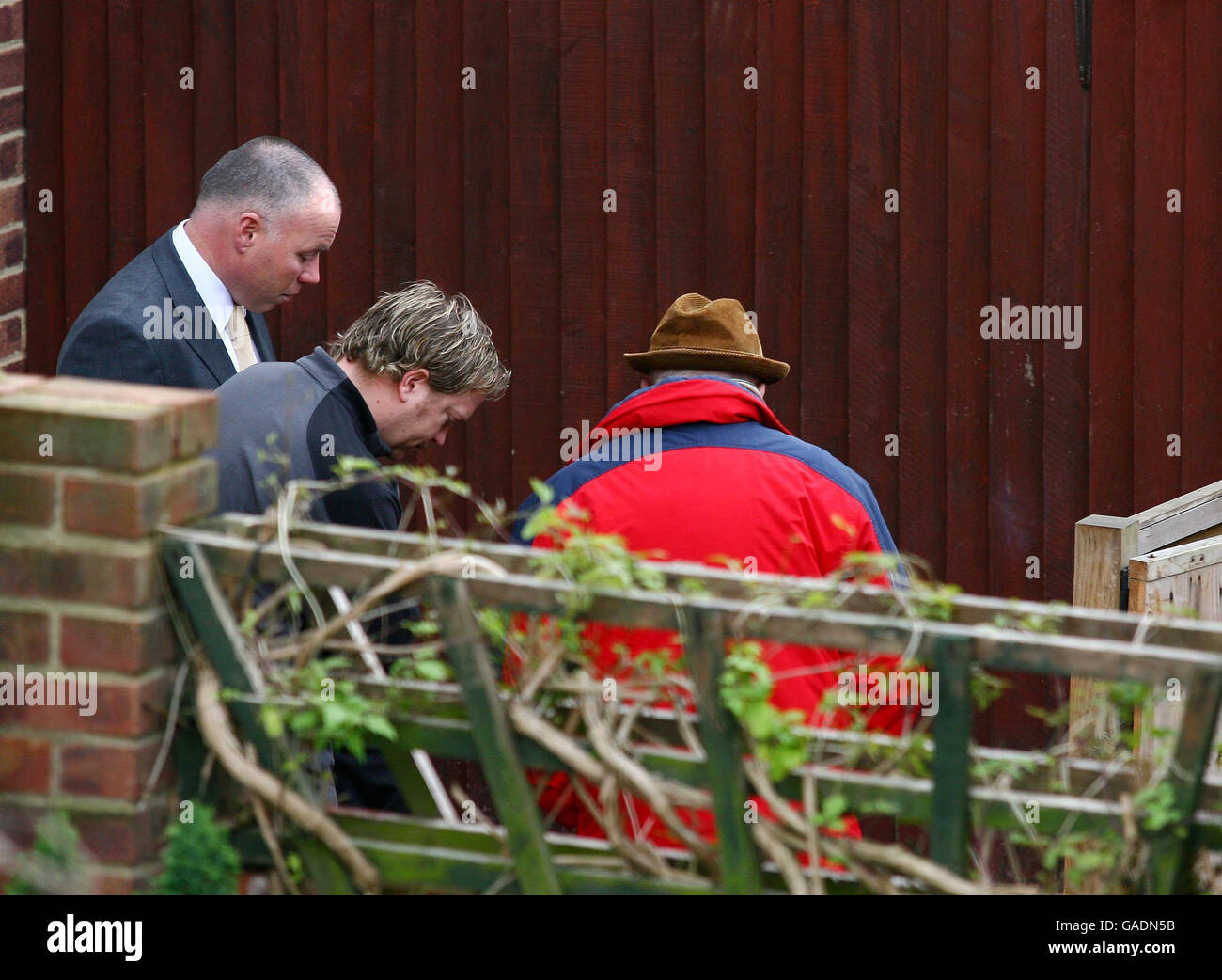 Ian McNicol (right) father of Dinah McNicol, accompanied by an unnamed relative (middle) and a senior police officer (left), visits the scene in the back garden at the former home of Peter Tobin in Margate, Kent, where the body of Dinah is thought to have been found. Stock Photo