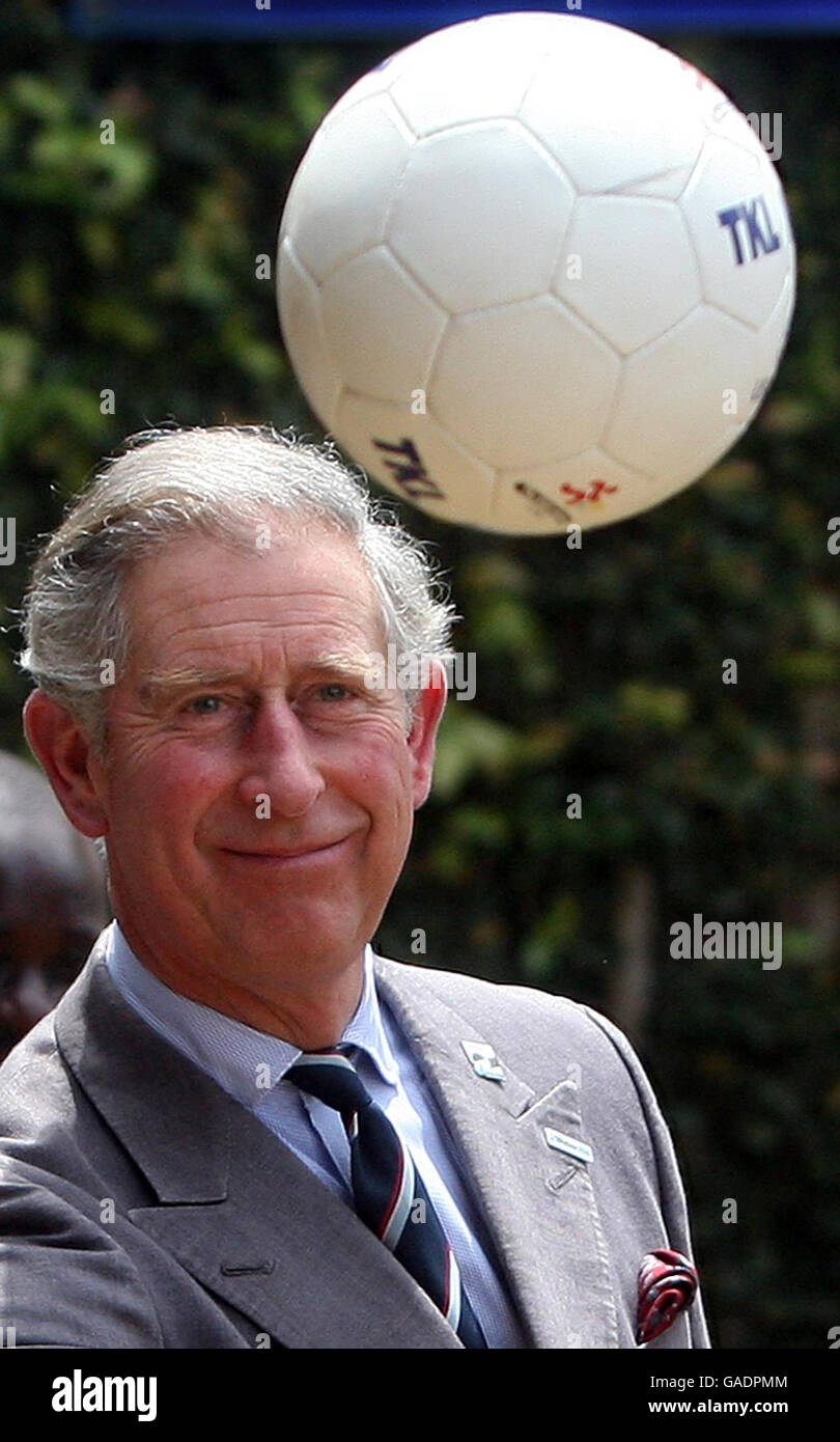 Prince Charles passes a football to a Ugandan children playing football ...