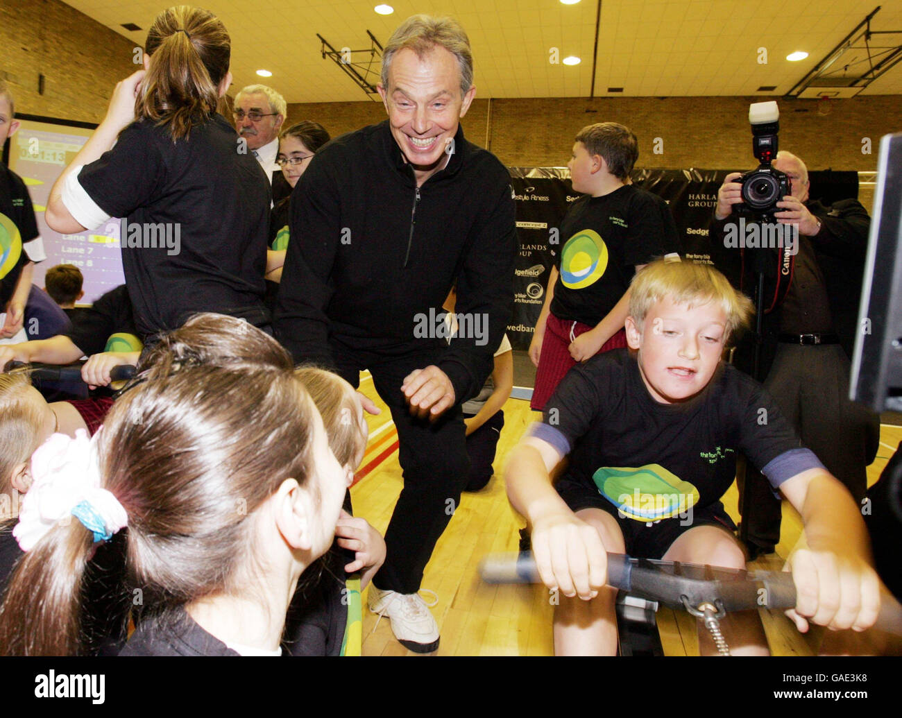 Former British Prime Minister Tony Blair watches as children take part