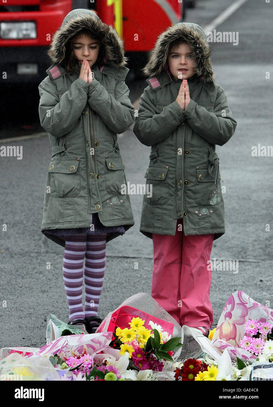 Sisters Anna Rose Taggart, 7, (left) and Katie Lee, 6, say a prayer