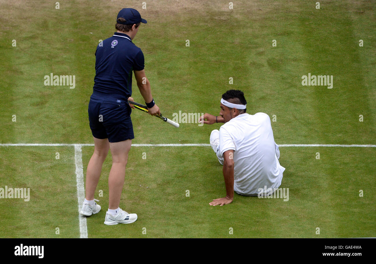 A ball boy hands a racquet back to Nick Kyrgios after he slips during his match against Andy