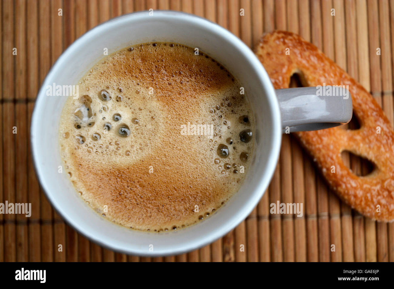 Grey cup of coffee in a mug on a bamboo placemat with cairn zen stones Stock Photo