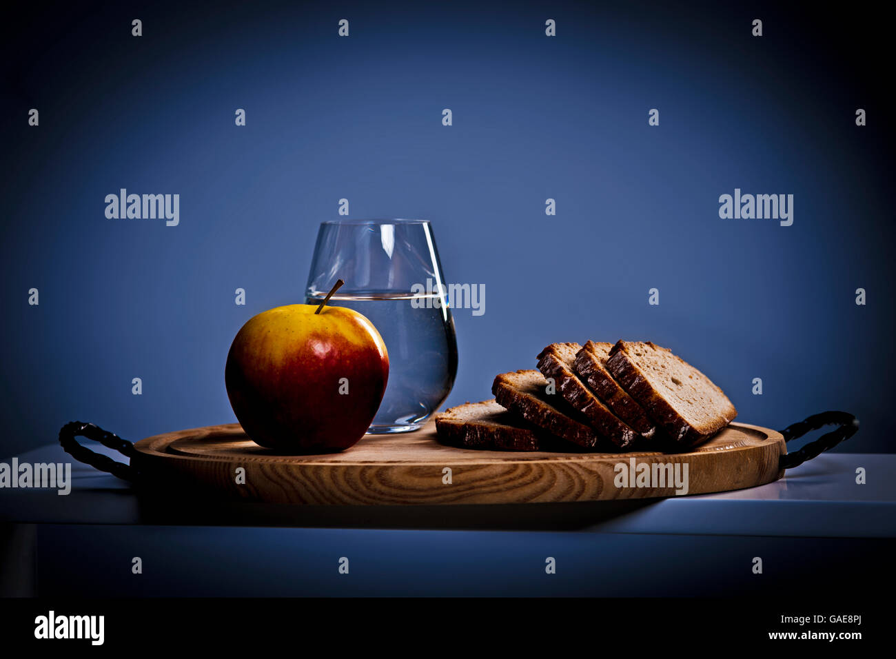 Glass of water, an apple and slices of bread Stock Photo