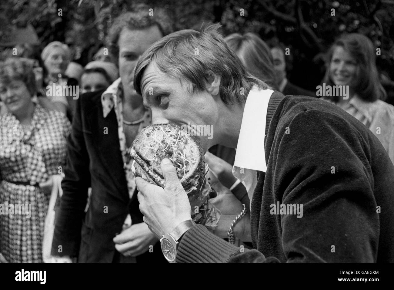 Footballing legend Johan Cruyff tucks into a giant salad sandwich after presenting The Silver Salad Bowl of Europe Challenge Trophy and winner medals to British school children at the Royal Netherlands Embassy. The trophy was awarded for the best essay on 'Holland, the salad bowl of Europe'. Stock Photo