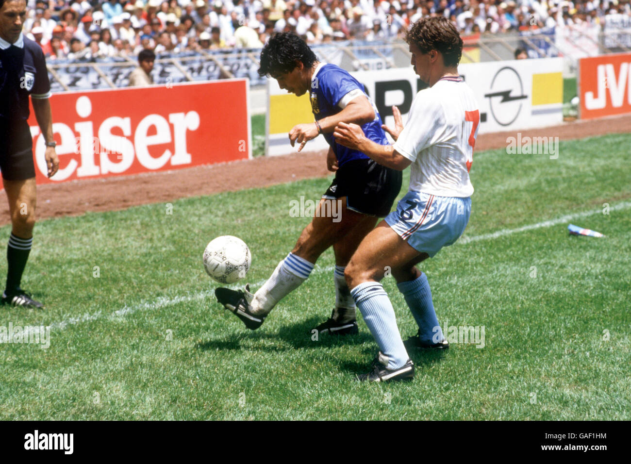 (L-R) Argentina's Diego Maradona juggles the ball as he shields it from England's Kenny Sansom Stock Photo