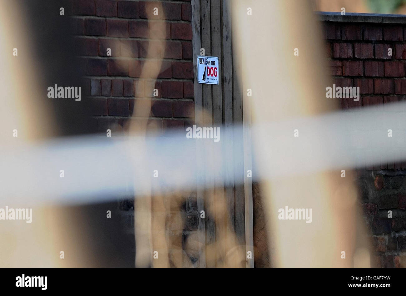 A sign warning visitors to Beware of the Dog is visible behind police tape at the house in Wakefield where one year old Archie Lee Hirst was killed by the family pet dog. Stock Photo